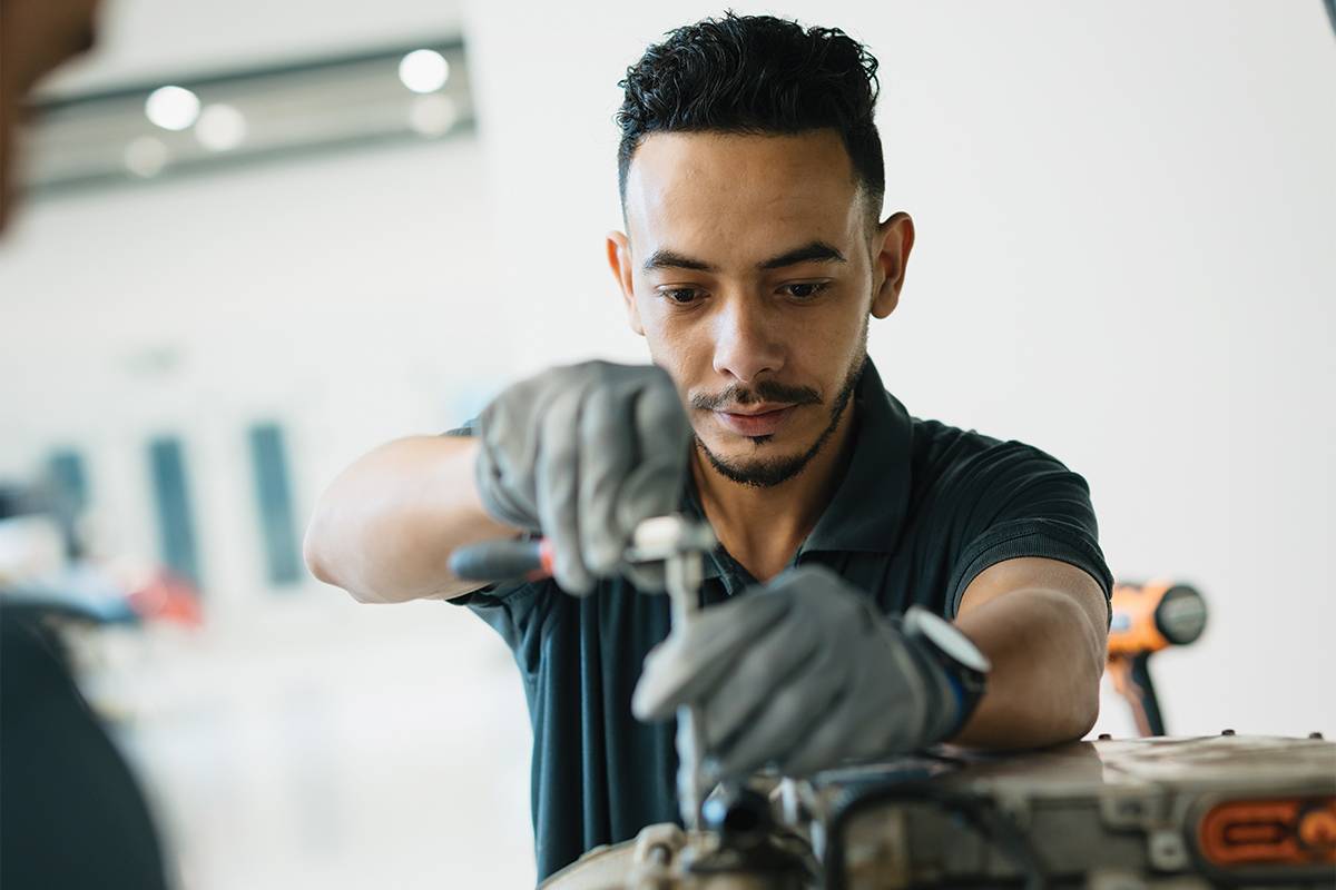 EVS Oman technician checking electric vehicle during extreme summer heat in Seeb 2026